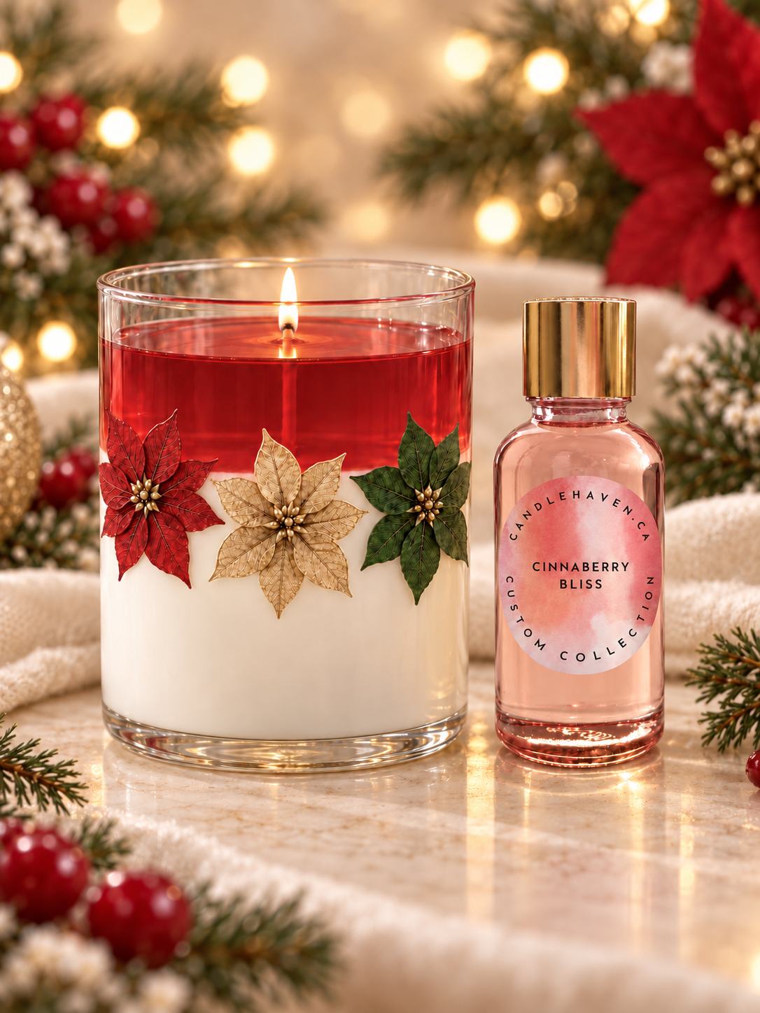 A lit holiday candle in a clear glass vessel with red wax on top, white wax below, and decorative poinsettia and holly accents, shown beside a small pink perfume bottle labeled Cinnaberry Bliss. The scene is styled with festive greenery, red berries, and warm blurred lights.