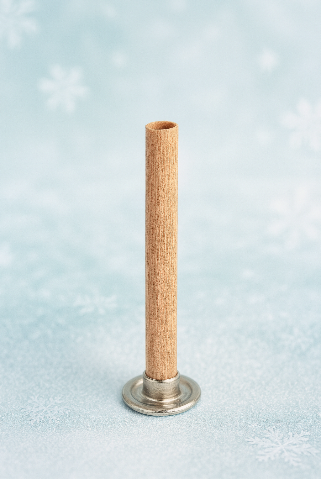 cylinder wooden wick with a wooden top and metal base on a light blue background with snowflake patterns.