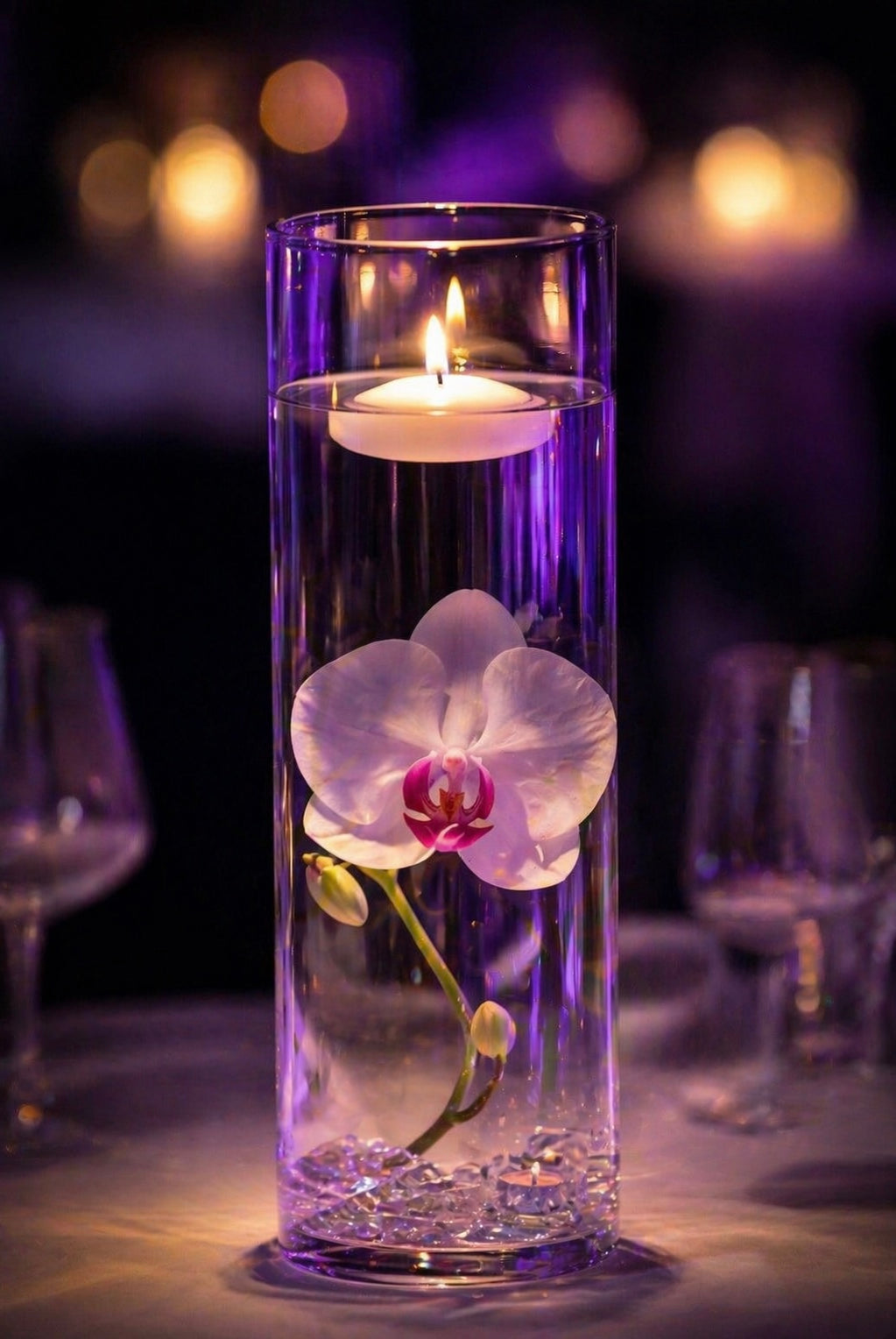 Floating candle in a cylinder vessel with an orchid inside