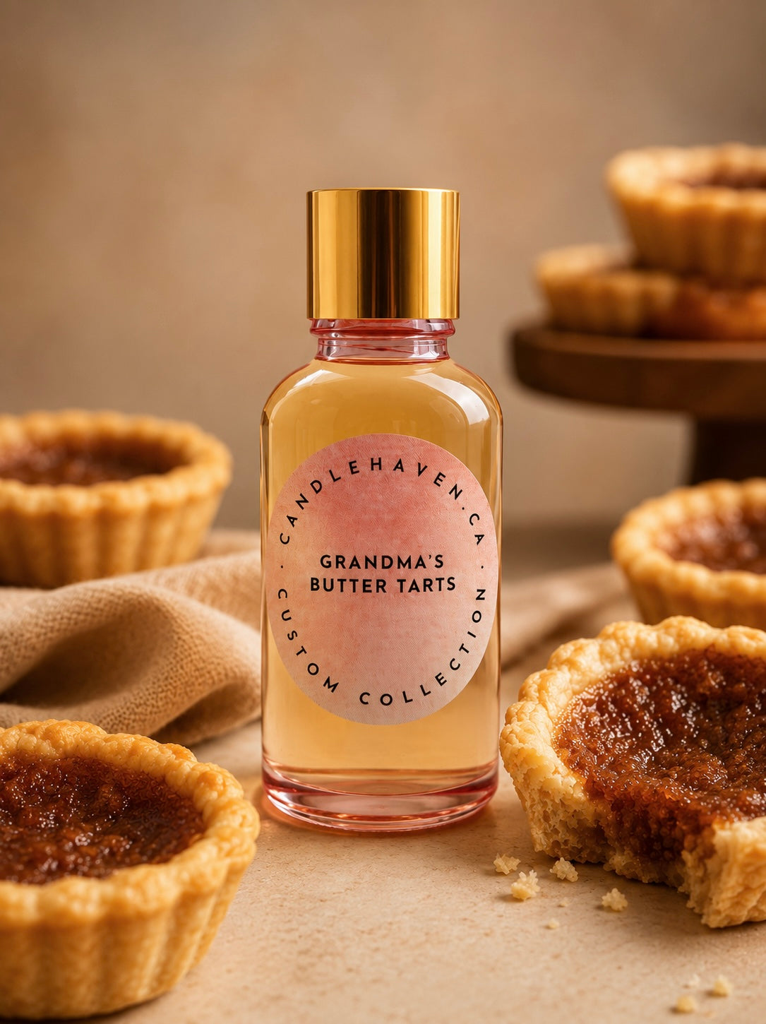 Bottle of 'Grandma's Butter Tarts' fragrance oil for candle making with butter tarts in the background