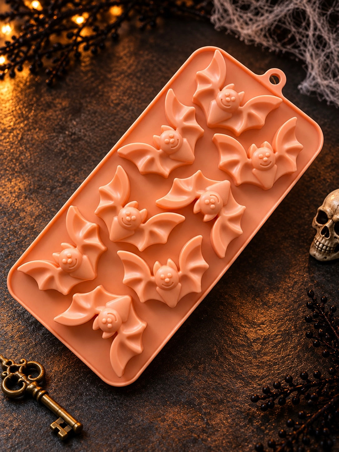 Orange mold for Halloween bats used in candle making shown on a dark Halloween background