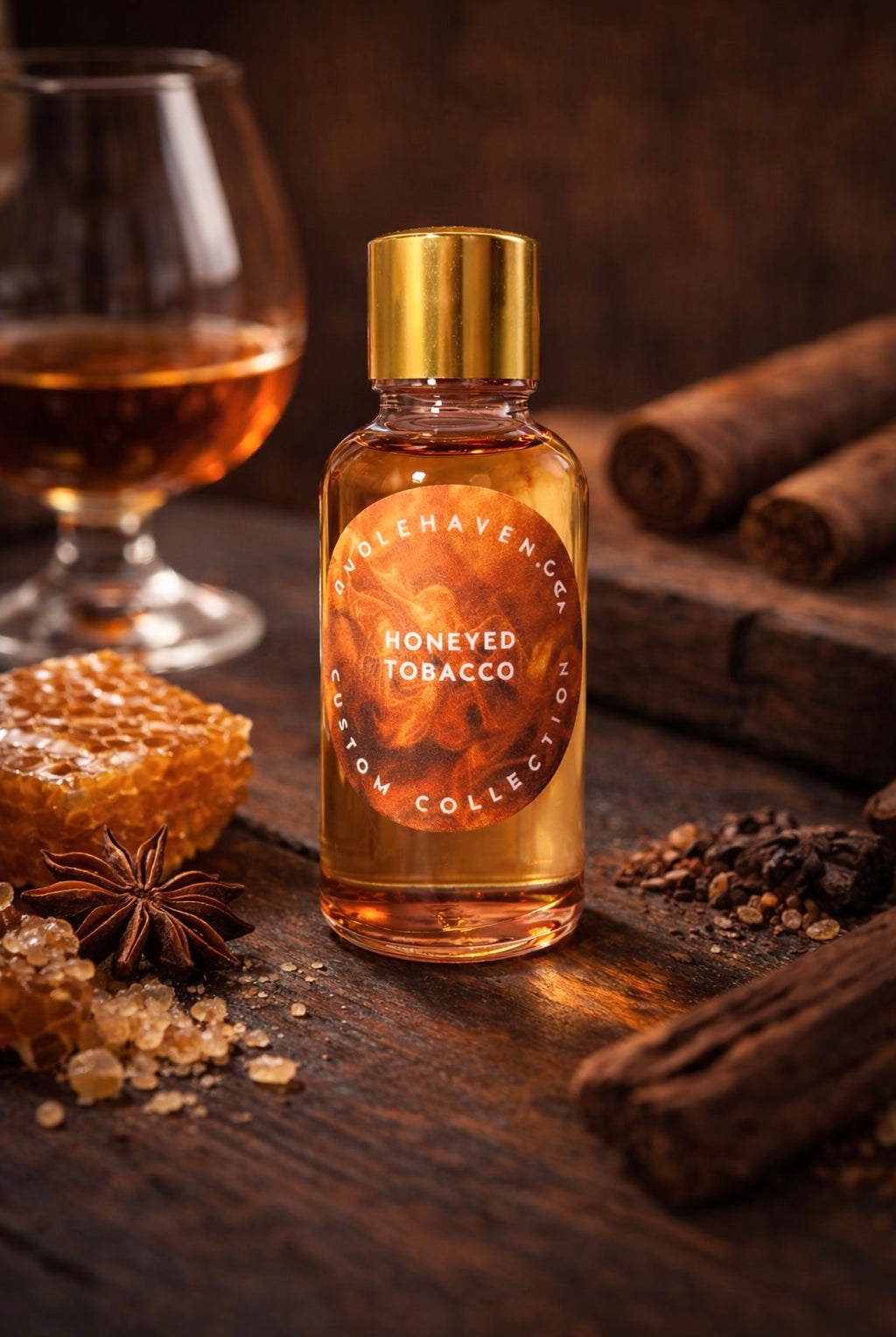 Bottle of 'Honeyed Tobacco’ candle fragrance oil on a wooden surface with cinnamon sticks and honeycomb.