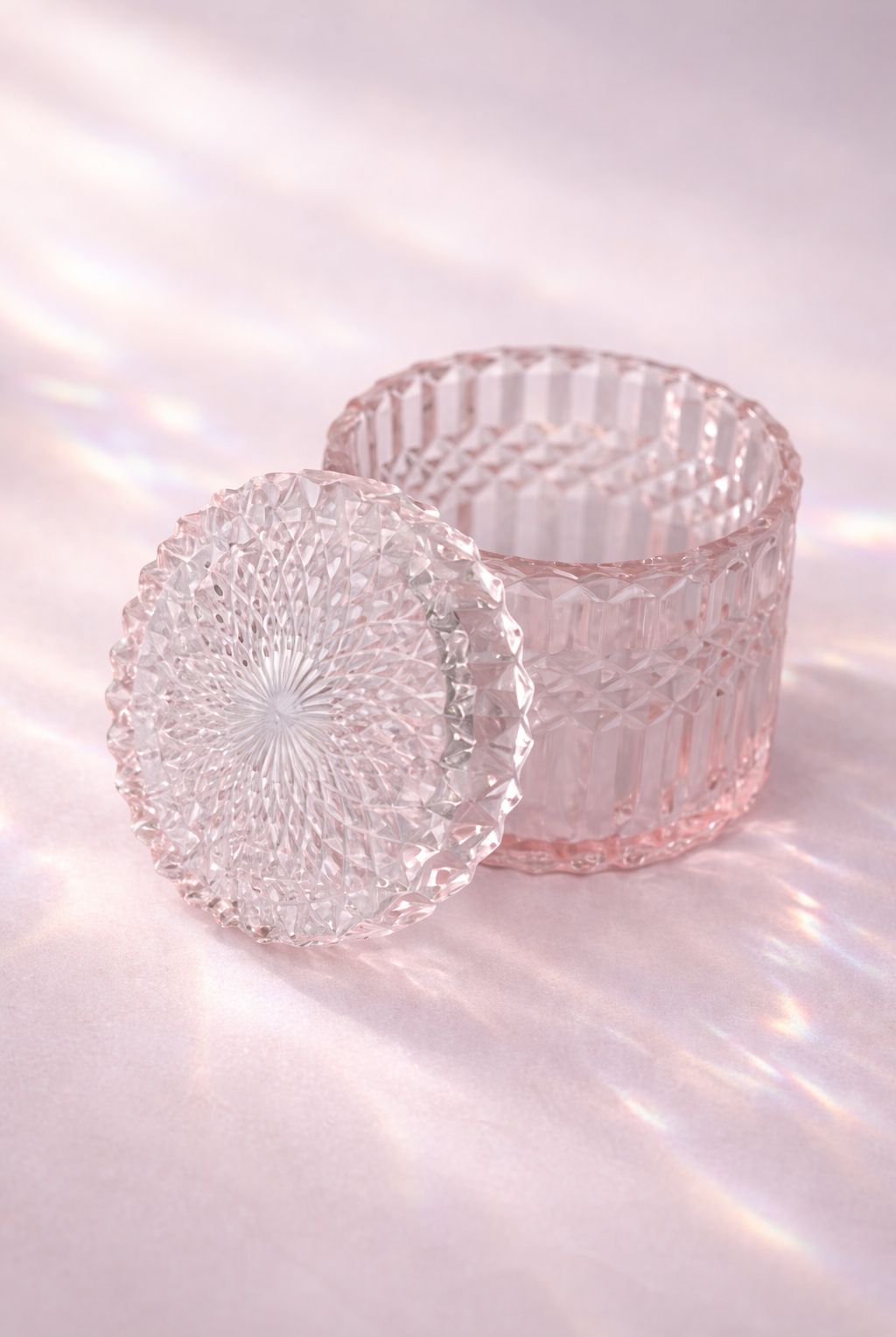 pink glass candle holders with textured designs on a reflective surface.