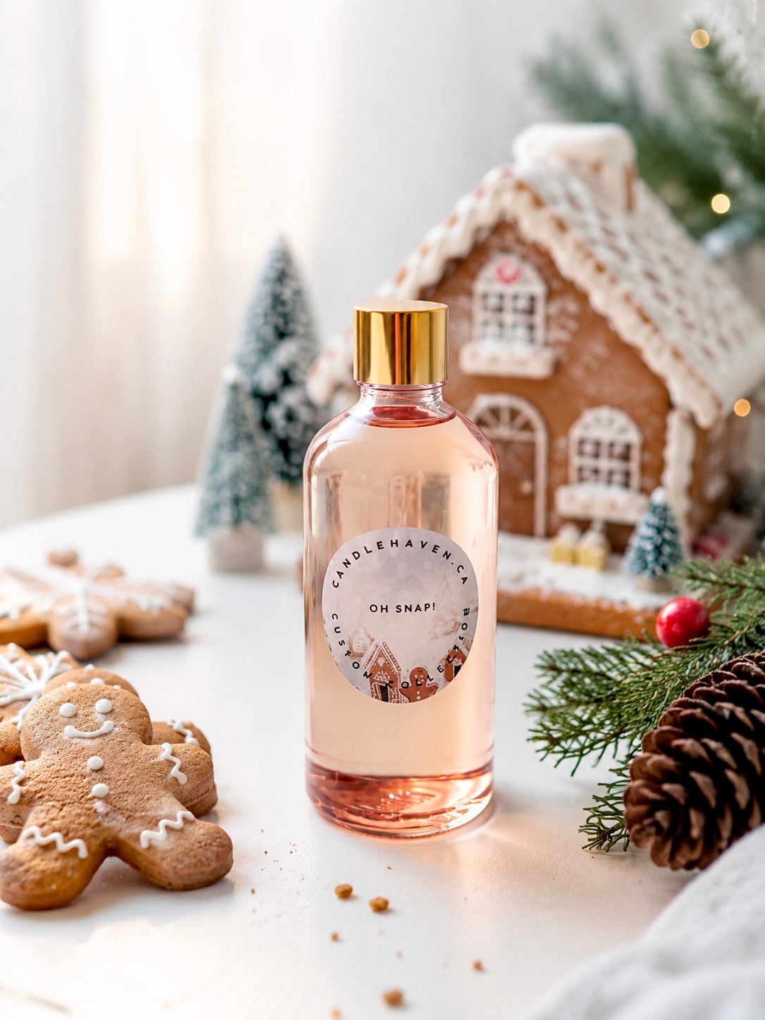 Bottle of Candle Haven 'Oh Snap!' fragrance oil for candle making with Christmas-themed decor including gingerbread cookies and a gingerbread house.