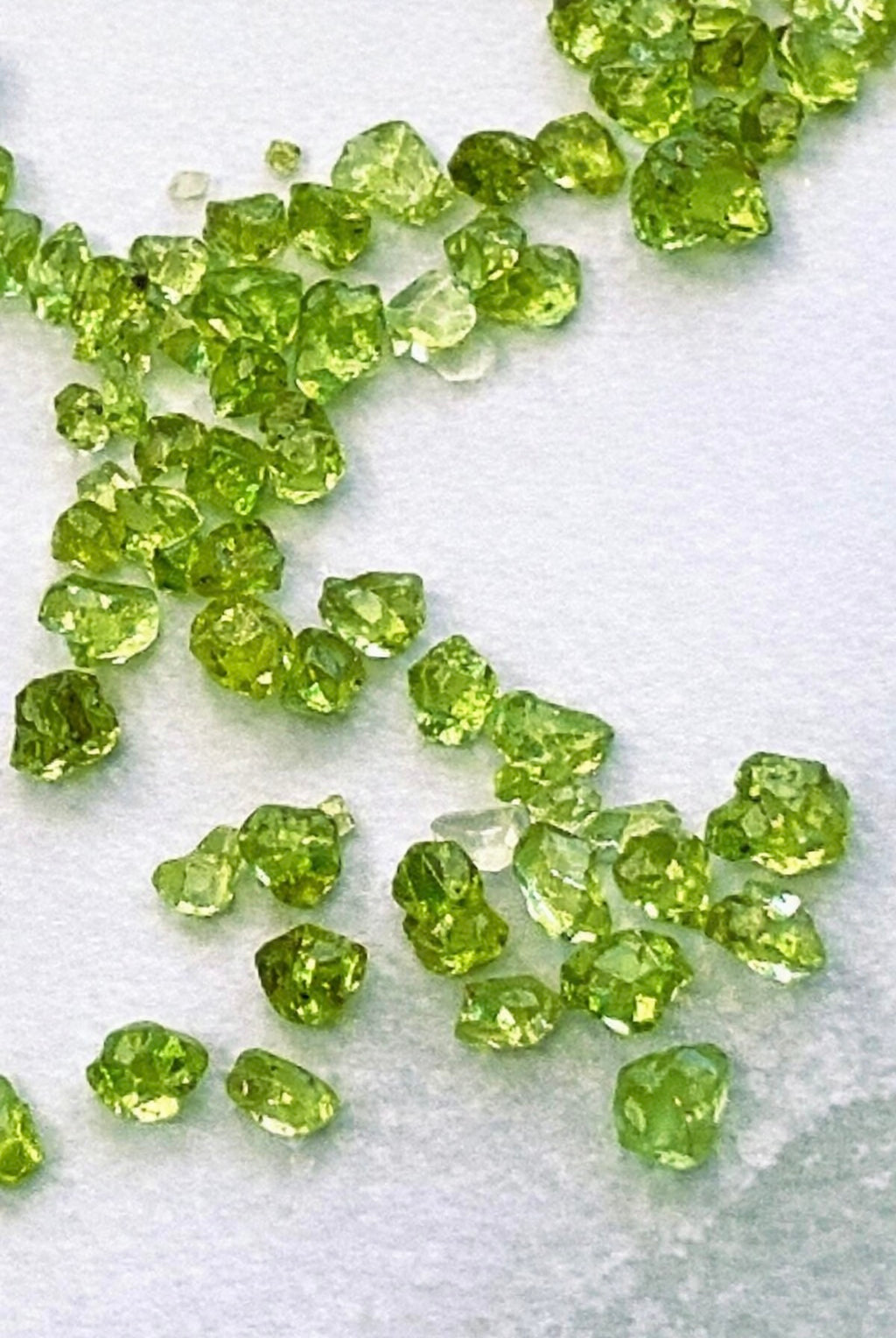 Peridot chips for candle making on a white background
