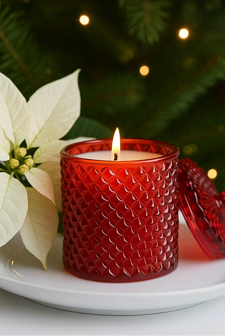 Red Geo Cut Vessel called Franciwith a lit candle inside with a by Candlehaven.ca with a pointsetta in the background