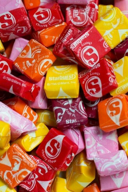 Bottle of Starburst Splash fragrance oil with vibrant fruit background.