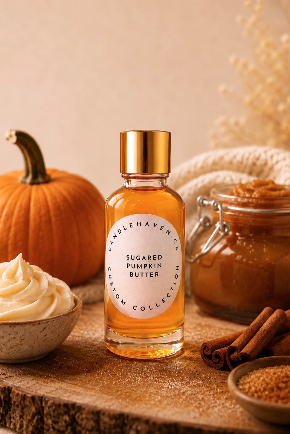 Bottle of sugared pumpkin butter candle fragrance oil on a wooden surface with pumpkins, cinnamon sticks, and a bowl of cream.