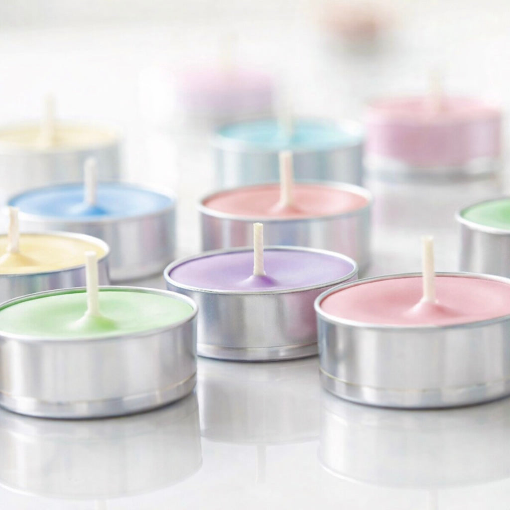 Pastel-colored tealight candles in tealight cups on a white background