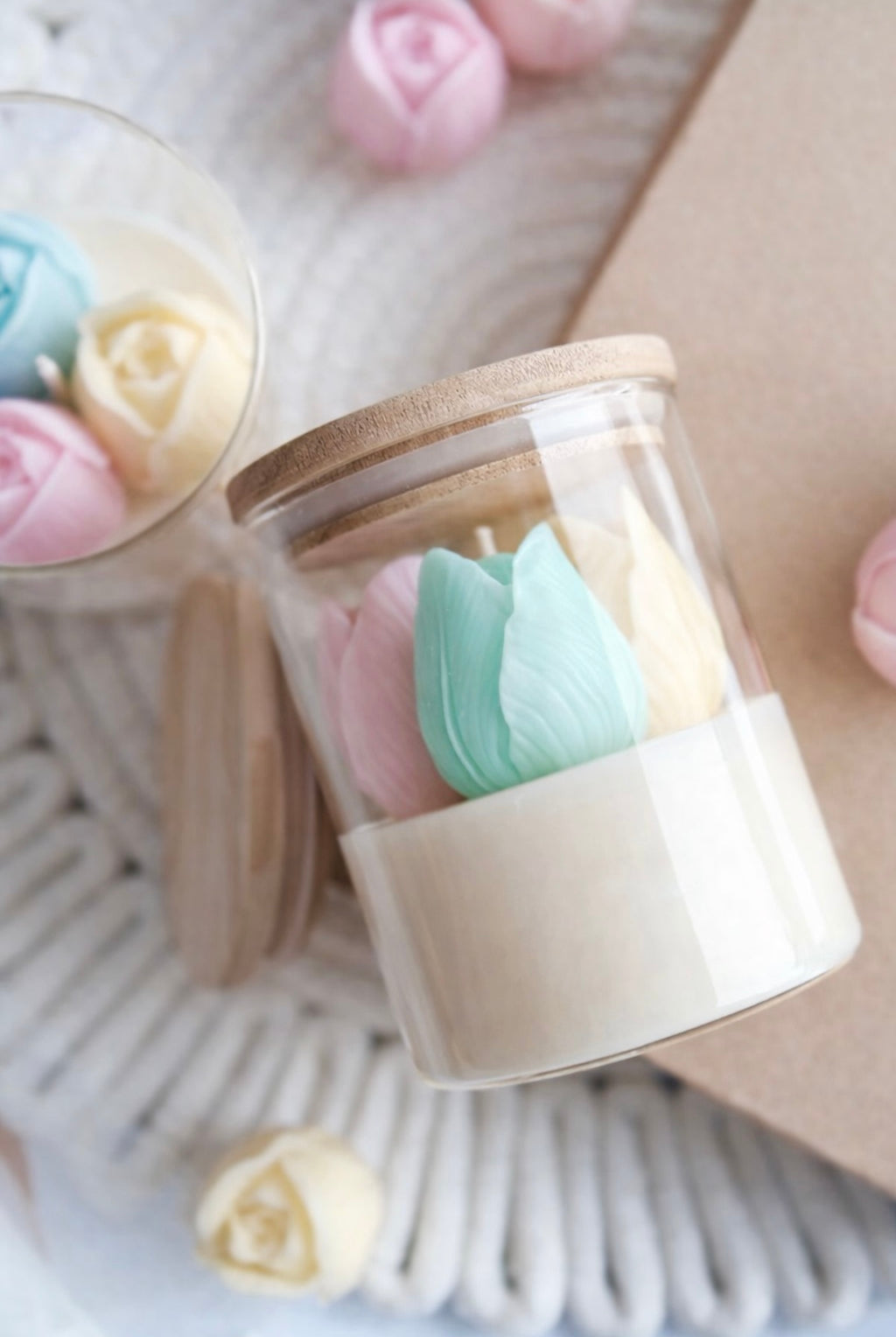 Glass jar with wooden lid containing colorful rose tulip embeds on a soft background