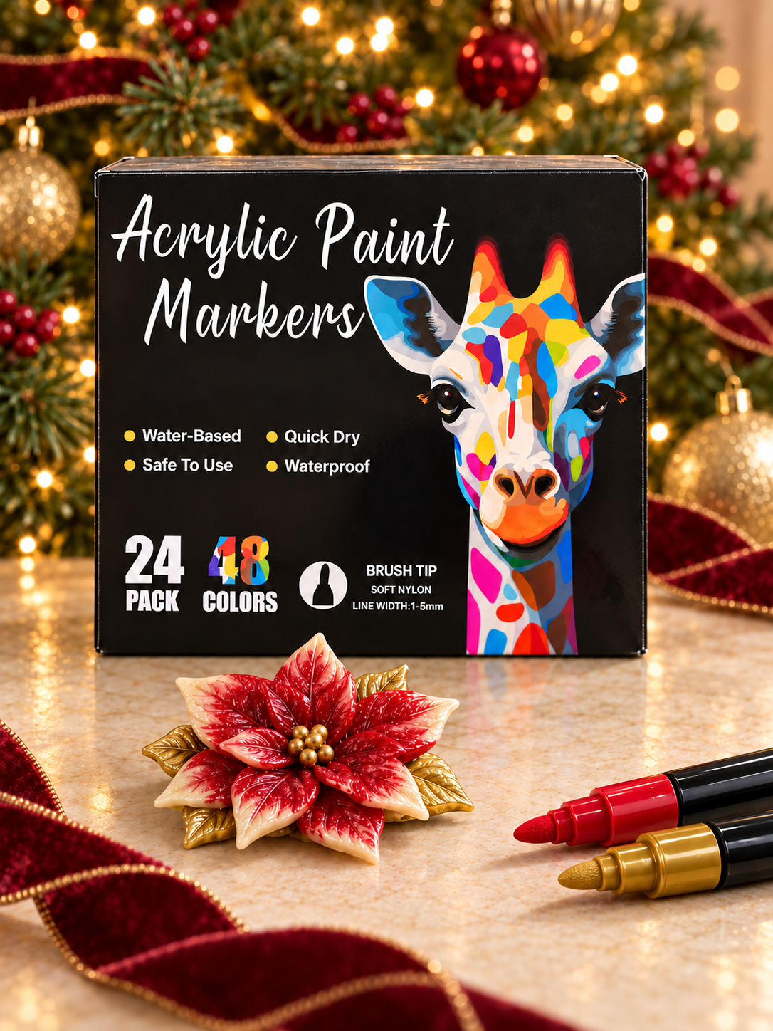 Acrylic paint marker box with red and gold markers beside a painted wax poinsettia, with a decorated Christmas tree behind.