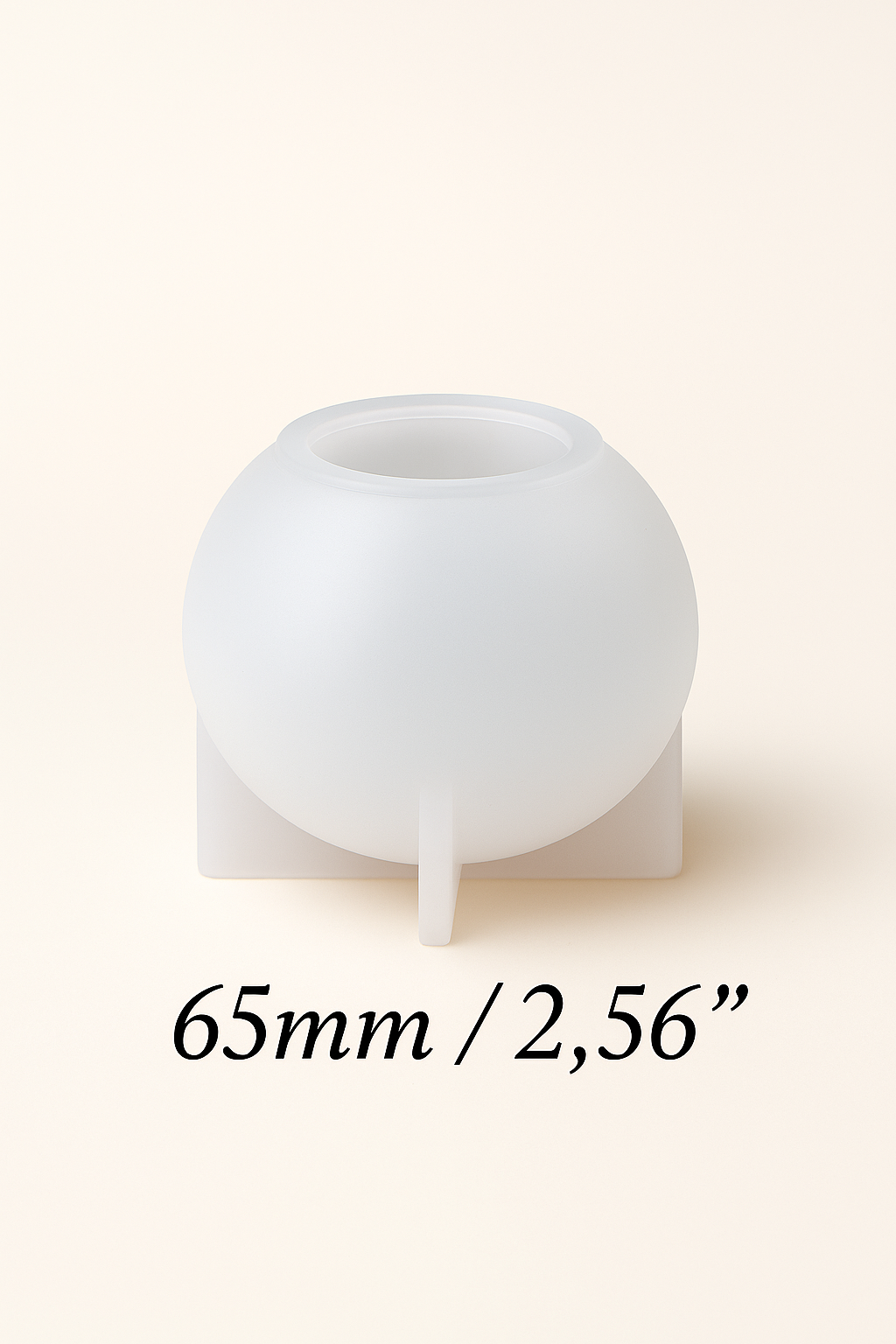White spherical silicone mold on a stand with measurement text '65mm / 2,56”' on a beige background