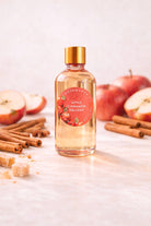 Bottle of Apple Cinnamon Delight fragrance oil with apple and cinnamon in a light background