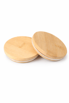 Two wooden bamboo lids for candle jars on a white background