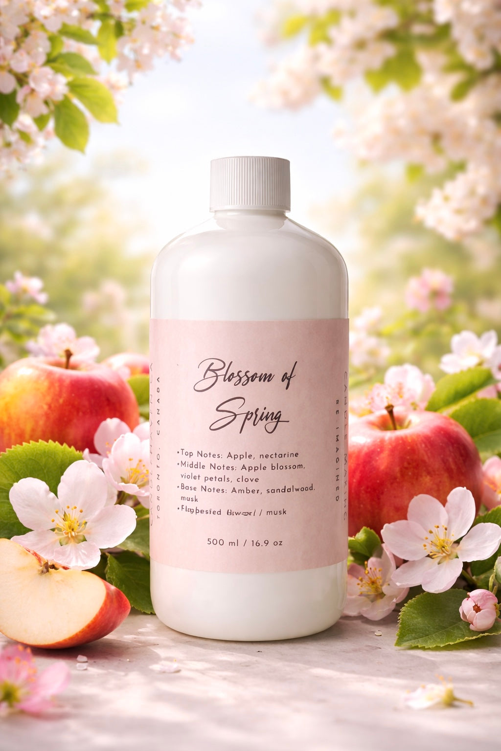 Bottle of 'Blossom of Spring' 500ml candle fragrance oil by Candlehaven.ca with apples and flowers in the background