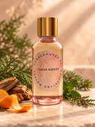 Bottle of Candlehaven’s Cedar Breeze fragrance oil for candle making on a background showing Cedar and an orange peel. 