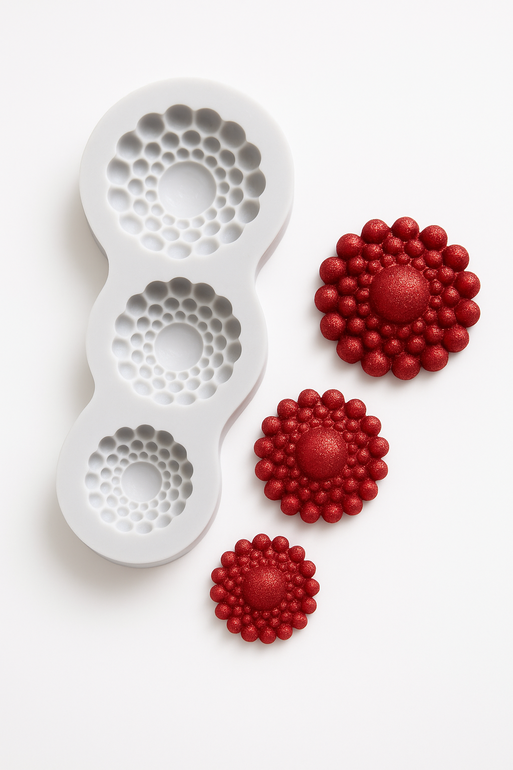 White silicone mold with red flower-shaped impressions on a white background