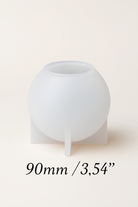White spherical silicone mold on a beige background with measurement text