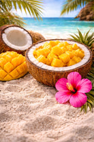 Coconut Mango fragrance oil | Coconut filled with mango pieces on a sandy beach with a pink flower and pineapple leaves.