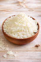 Coco soy wax for candle making in a wooden bowl on a light background 