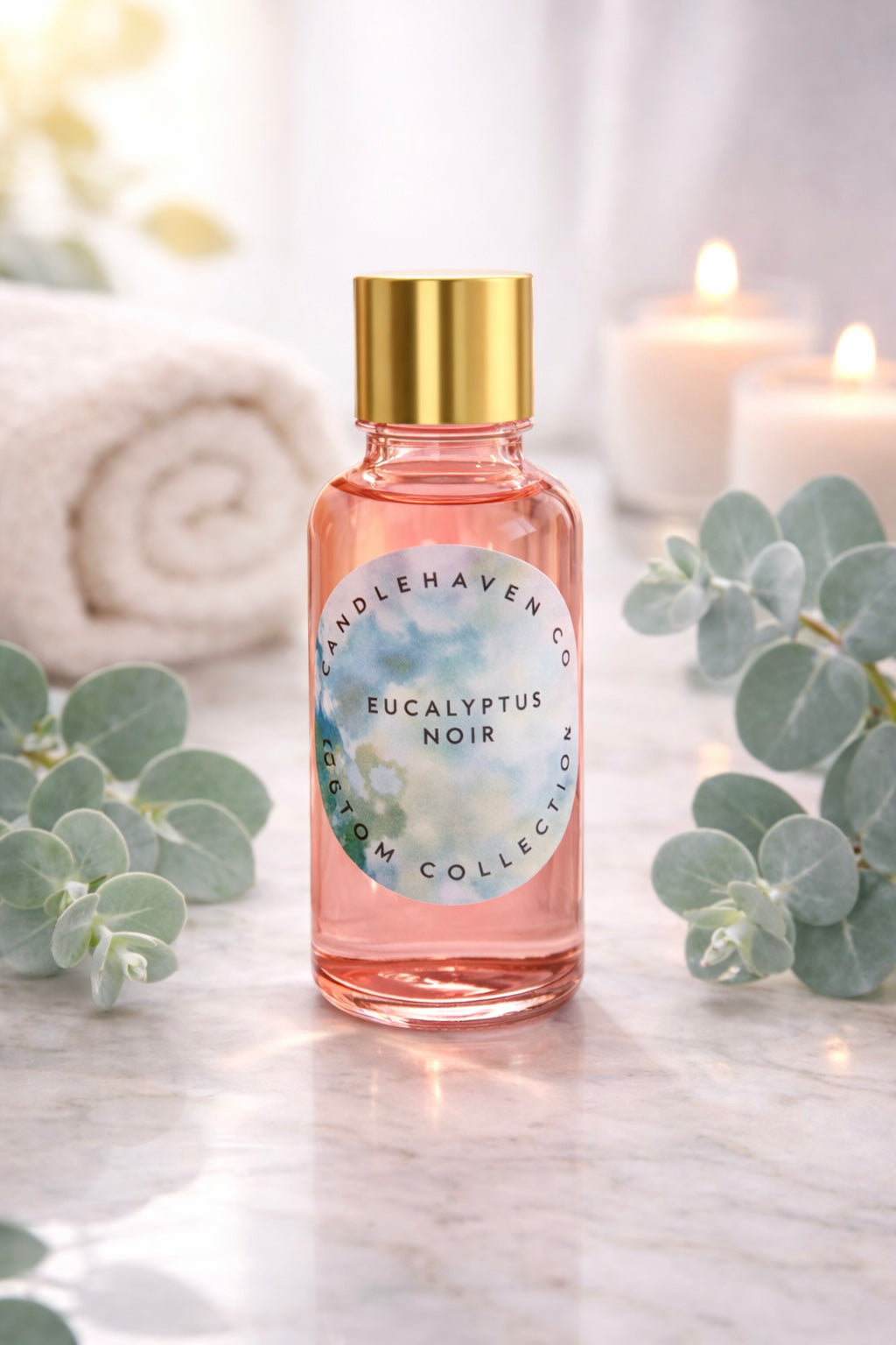 Bottle of Candlehaven.ca’s Eucalyptus Noir candle making fragrance oil with gold cap on a marble surface with eucalyptus leaves.