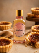 Bottle of 'Grandma's Butter Tarts' fragrance oil for candle making with butter tarts in the background