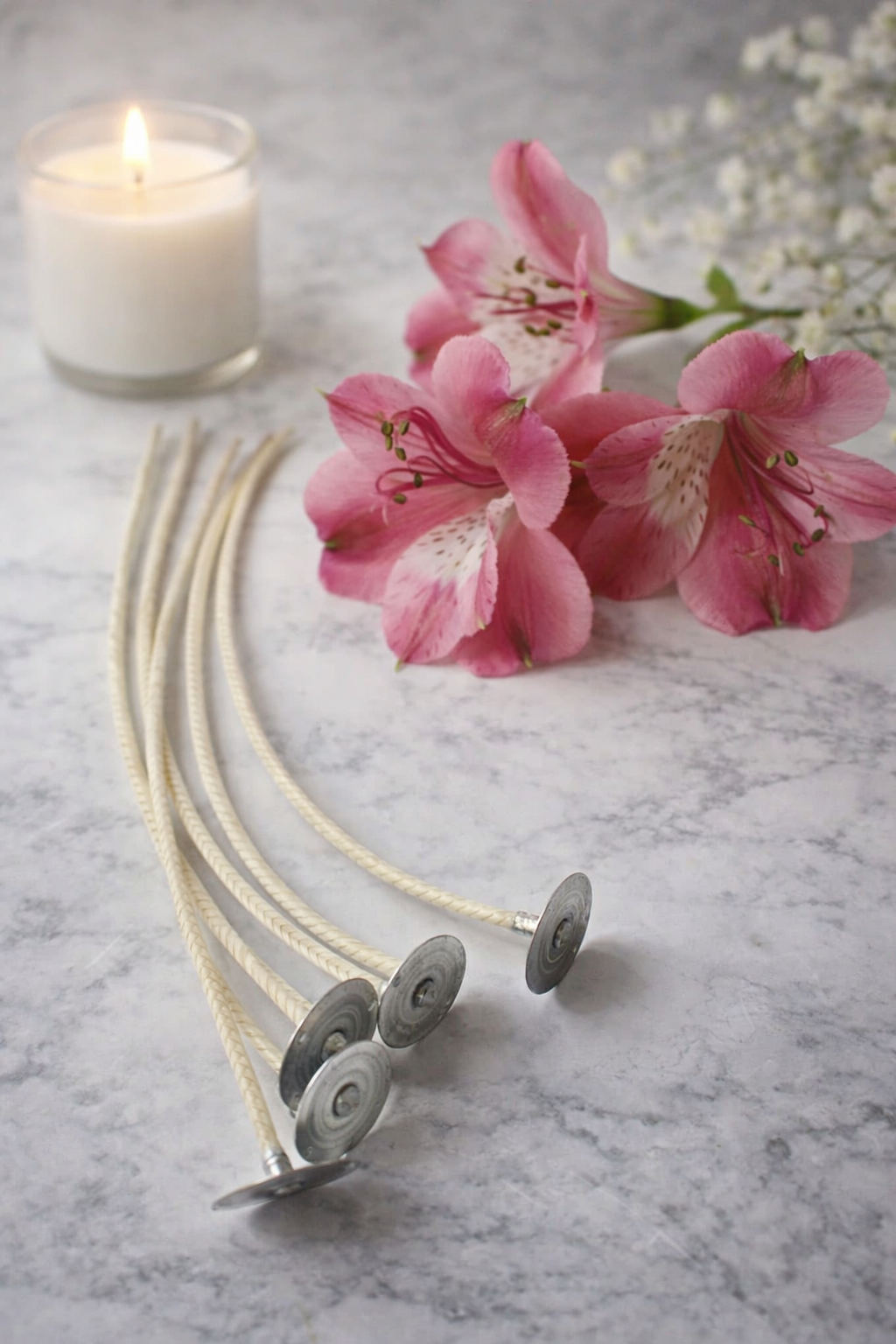 HTP wicks for candle making with floral and candle elements on a marble surface