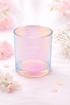 Iridescent glass candle jar on a light background with flowers