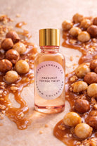 Bottle of 'Hazelnut Toffee Twist' with hazelnuts and caramel on a light background