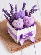 Decorative box with purple wax hearts and lavender flowers on a wooden surface