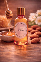 Bottle of Candlehaven Honey Almond fragrance with almonds and honeycomb on a wooden surface