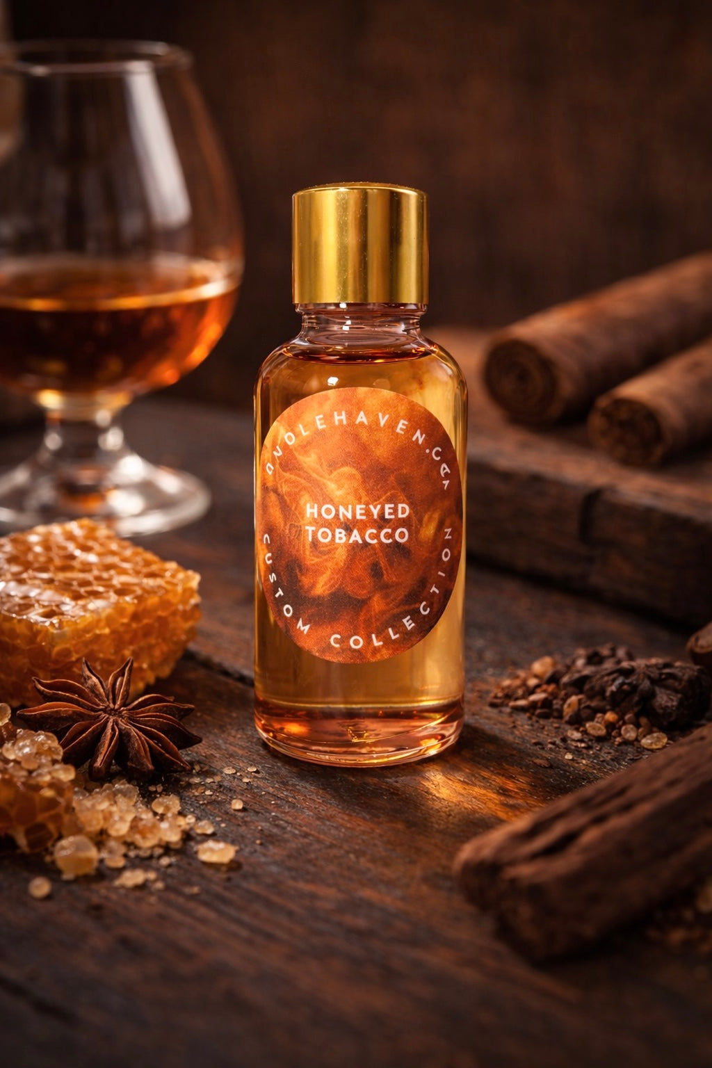 Bottle of 'Honeyed Tobacco’ candle fragrance oil on a wooden surface with cinnamon sticks and honeycomb.