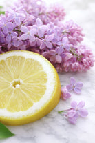 Slice of lemon with lilacs on a marble surface | candle fragrance oils sold in canada | lilac lemondrop fragrance oil for candle making