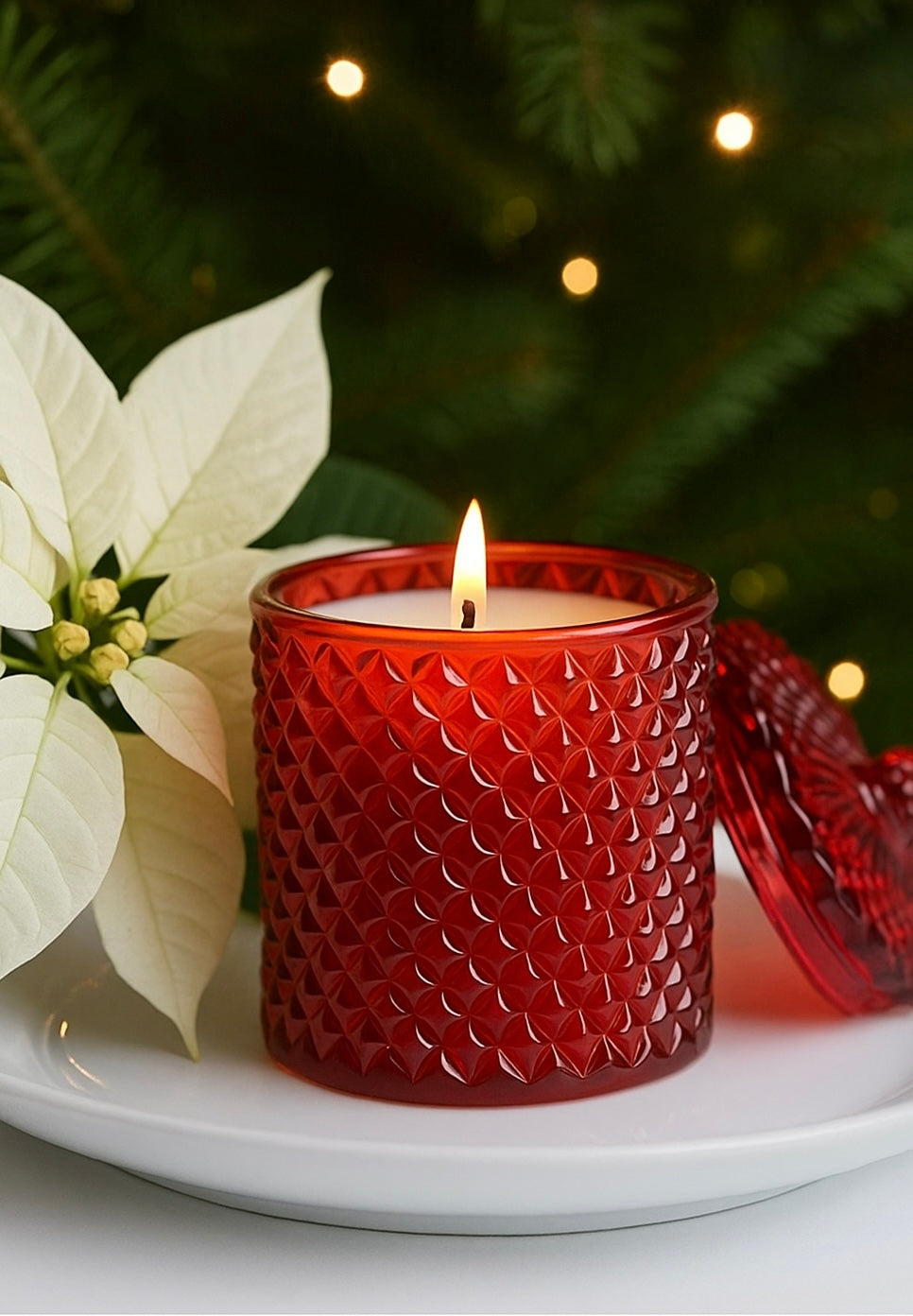Red Geo Cut Vessel called Franciwith a lit candle inside with a by Candlehaven.ca with a pointsetta in the background
