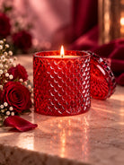 Red glass vessel and lid used for candle making on a romantic background with red roses 