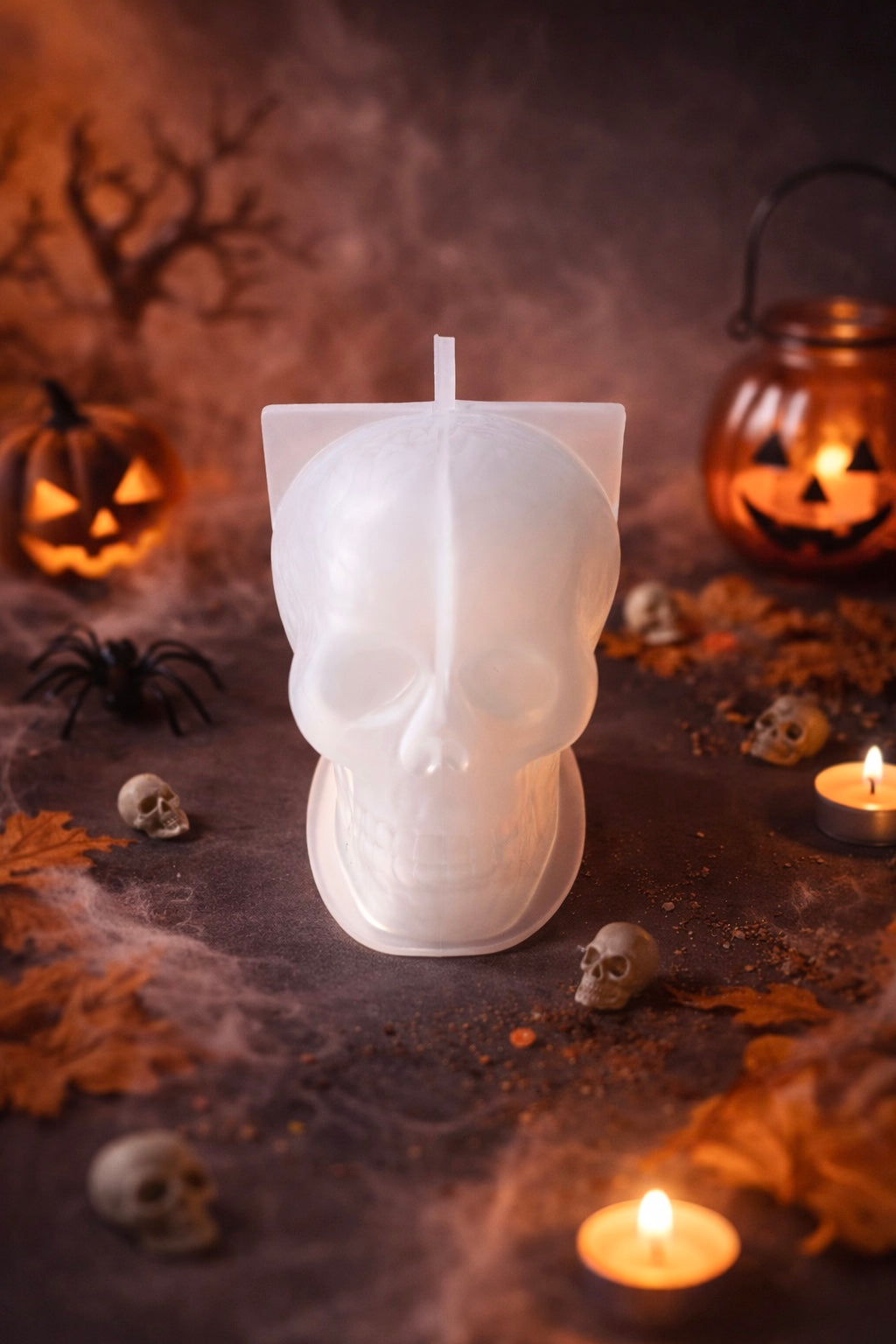 Skull shaped silicone Mold for candles on a dark surface with Halloween decorations