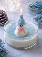 A wax snowman sitting atop a bed of white wax