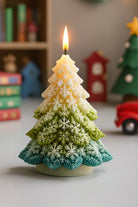 Decorative candle shaped like a Christmas tree with a lit flame, set against a festive background made with a Snowflake Tree Silicone Mold from Candlehaven.ca. This is used for candle making in Canada.