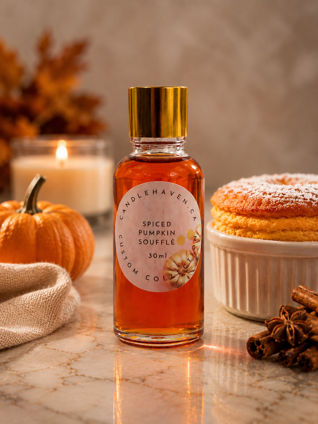 Bottle of spiced pumpkin souffle fragrance oil with a pumpkin, candle, and dessert in the background.