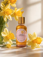 Spring Daffodils fragrance oil bottle by candlehaven.ca used in candle making on a light background with daffodils. 