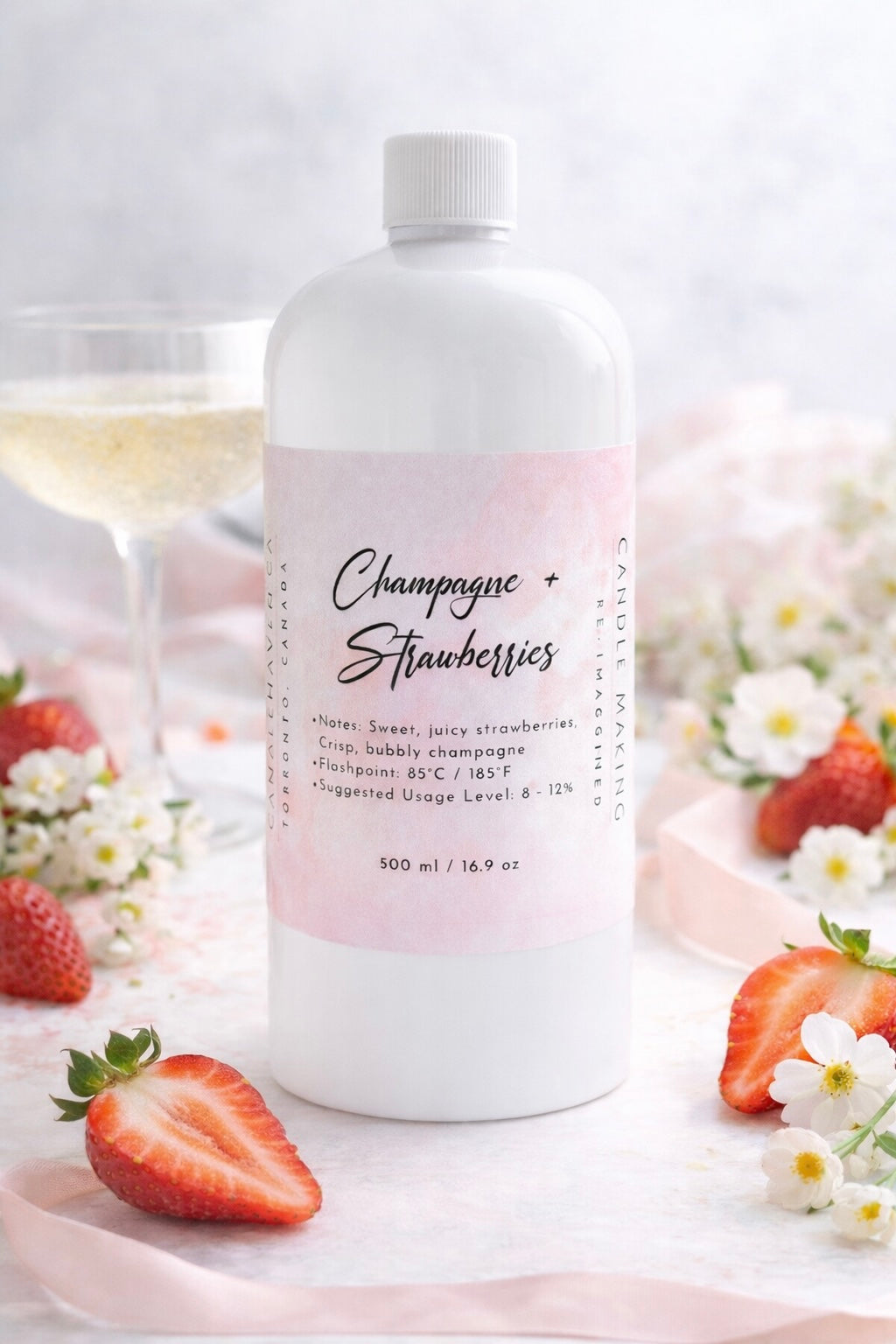 Bottle of champagne and strawberries fragrance oil on a light background 