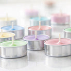 Pastel-colored tealight candles in tealight cups on a white background 