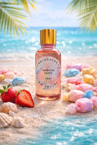 Bottle of Candlehaven.ca ‘Tropical Taffy’ candle fragrance oil on a beach with seashells and strawberry