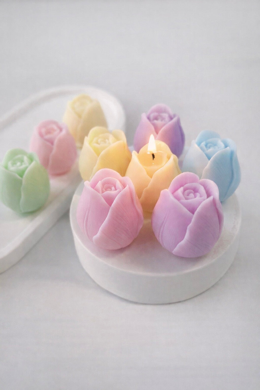 Pastel tulip rose shaped candles on a white background 