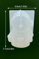 Silicone mold shaped like a character with dimensions indicated on a dark background used in candle making in Canada